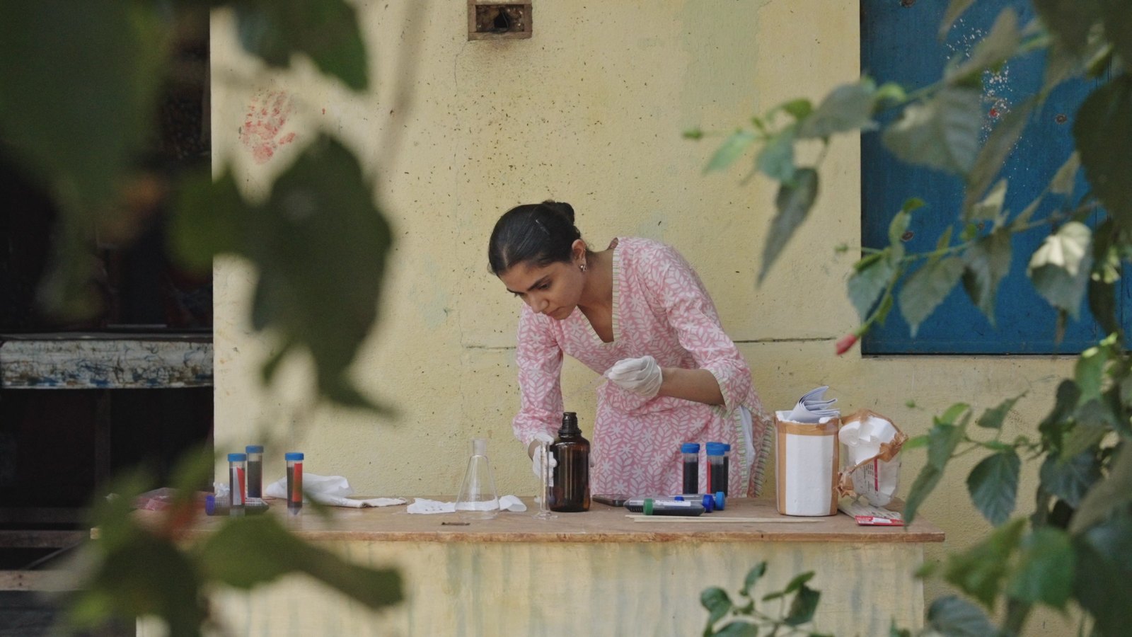 Vibhuti Amin working at a field bench with flasks and sample tubes